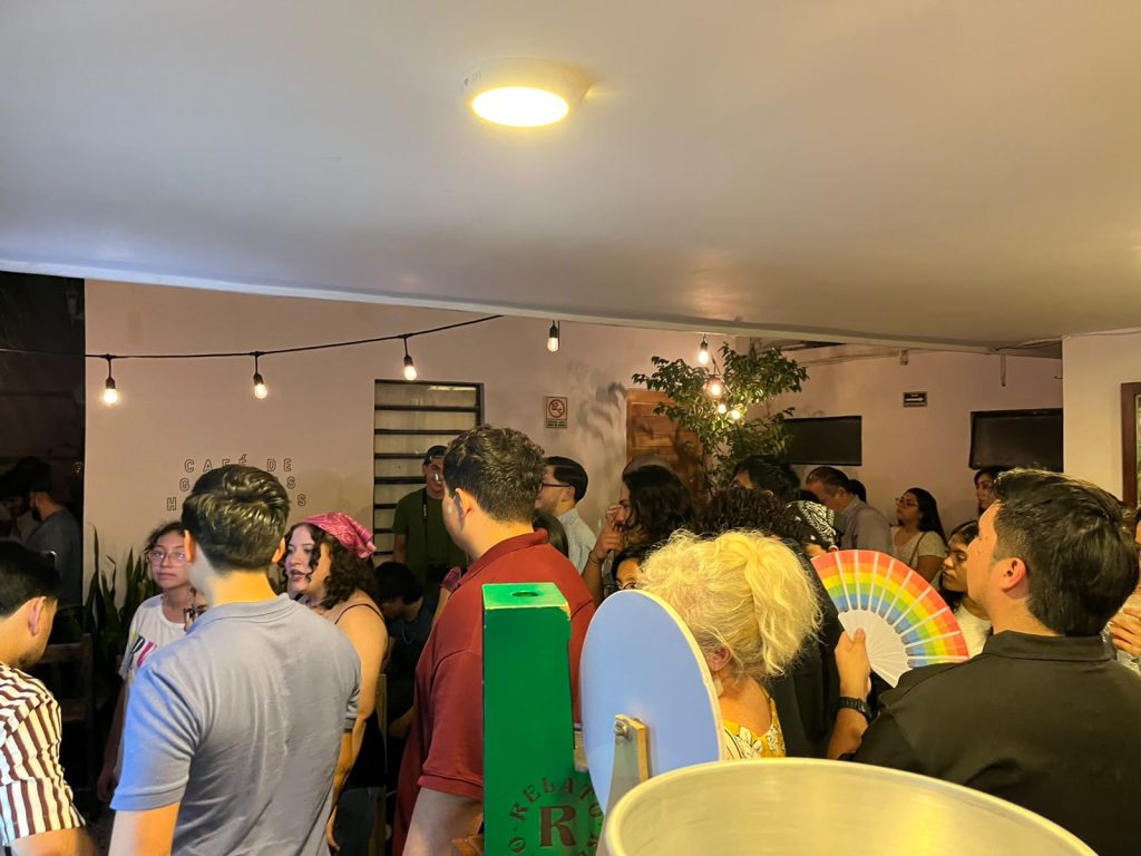 Asistentes reunidos en un evento de comunidad en Relato junto al letrero de la marca